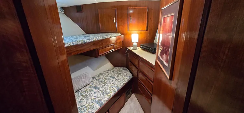 Slide: The Image of 1979 Hatteras 60 Enclosed Bridge Convertible cabin with wooden interior and bunk beds. - 35