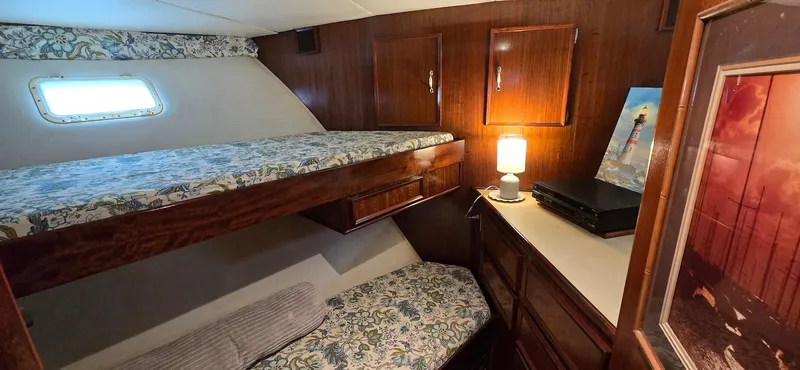 Slide: The Image of 1979 Hatteras 60 Enclosed Bridge Convertible cabin with bunk beds and wooden interior. - 36