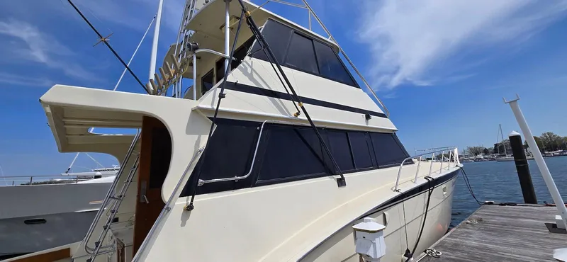 Slide: The Image of 1979 Hatteras 60 Enclosed Bridge Convertible yacht docked at marina under blue sky. - 4