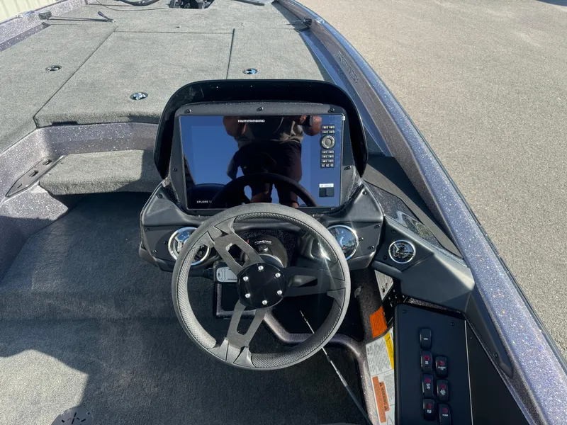 Slide: The Image of 2025 Skeeter ZXR20SE boat dashboard with steering wheel and electronic display. - 14