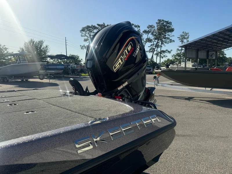 Slide: The Image of 2025 Skeeter ZXR20SE boat with powerful outboard motor, parked outdoors under clear sky. - 17