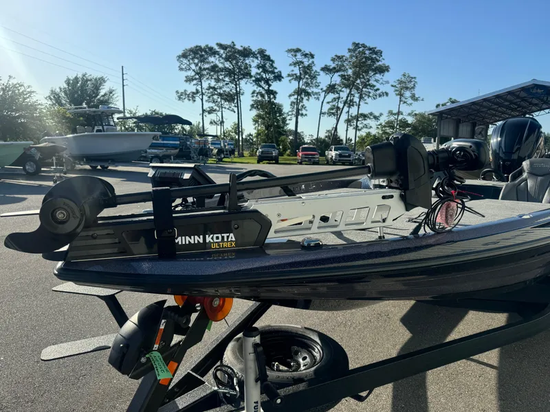 Slide: The Image of 2025 Skeeter ZXR20SE boat with Minn Kota trolling motor in a sunny outdoor setting. - 2