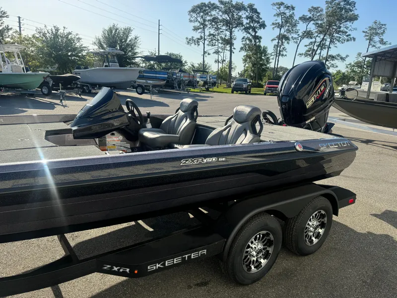 Slide: The Image of 2025 Skeeter ZXR20SE boat on trailer, parked outdoors with trees and other boats in background. - 3