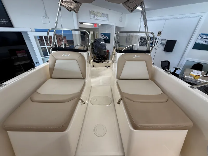 Slide: The Image of 2023 Scout 175 Sport Dorado boat interior with beige seating and motor view. - 9