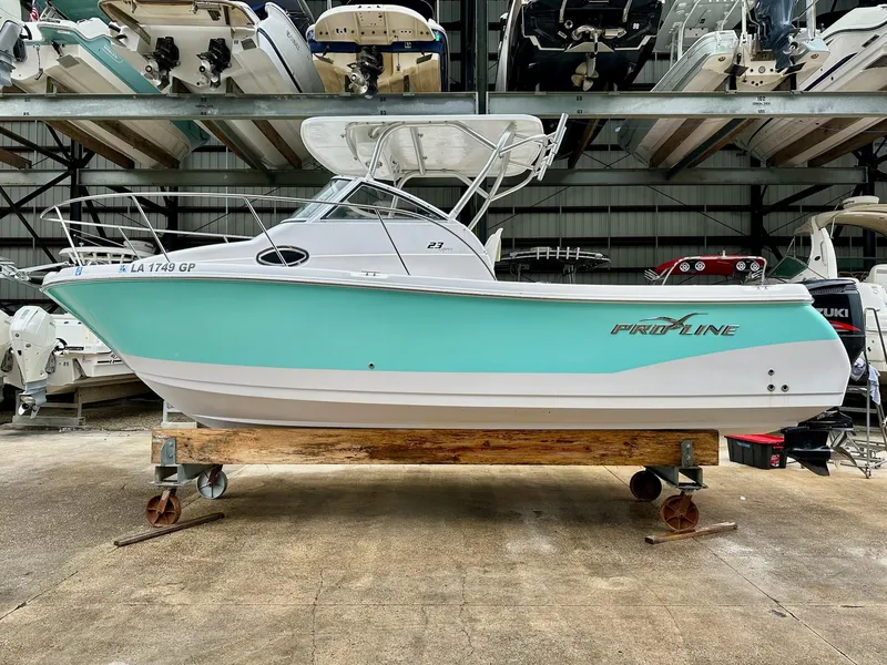 Slide: The Image of 2007 Pro-Line 23 Express boat in storage, mint green and white hull. - 2