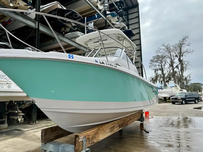 Slide: The Image of 2007 Pro-Line 23 Express boat in storage, featuring a teal hull and white upper deck. - 3