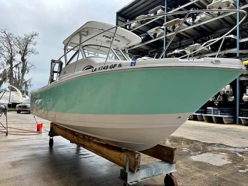 Slide: The Image of 2007 Pro-Line 23 Express boat on a stand, light blue hull, marina background. - 4