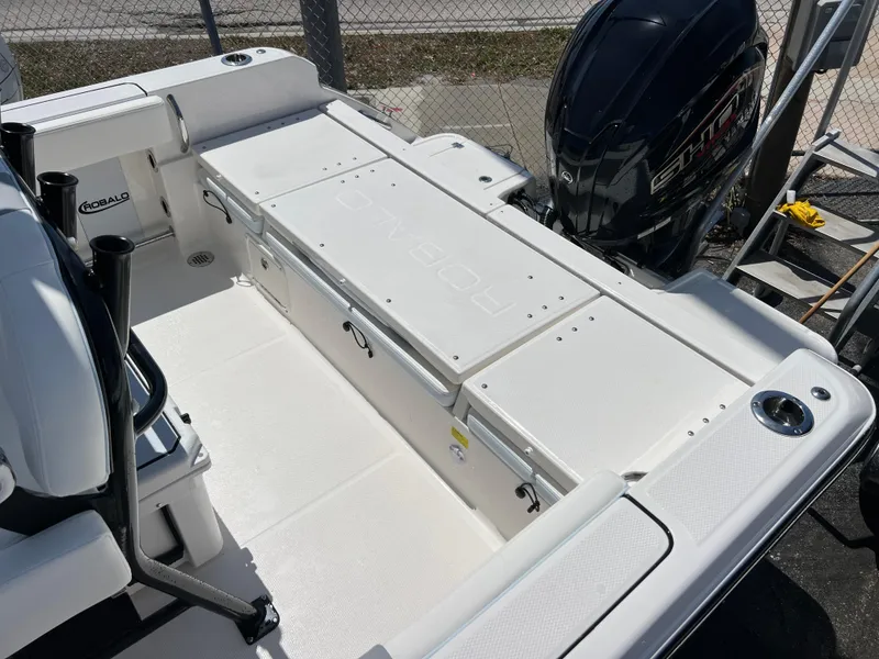 Slide: The Image of 2025 Robalo R232 Explorer boat deck with storage compartments and outboard motor. - 16