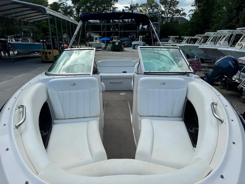 Slide: The Image of 2006 Regal 2200 Bowrider with white seating, docked among other boats. - 10