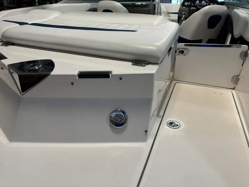 Slide: The Image of 2006 Regal 2200 Bowrider interior, featuring white seating and open storage compartment. - 25