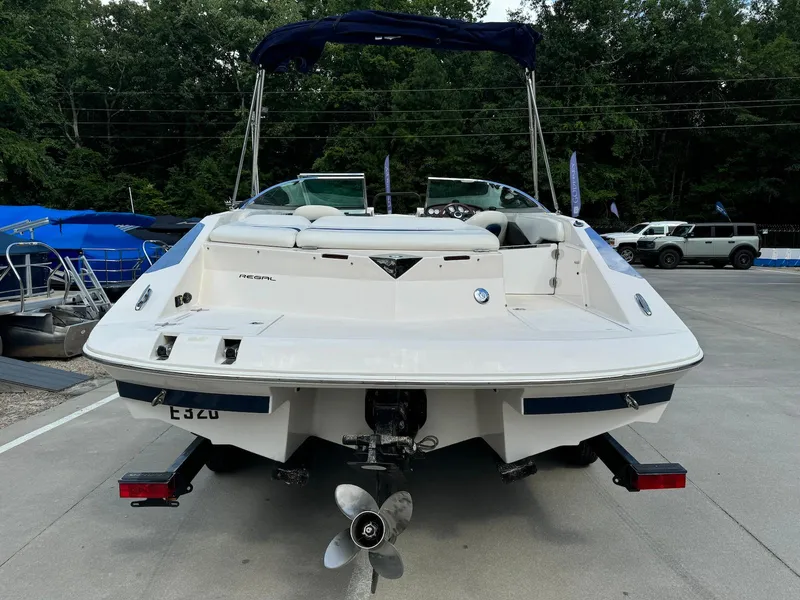 Slide: The Image of 2006 Regal 2200 Bowrider boat, rear view, parked on a trailer in a marina. - 3