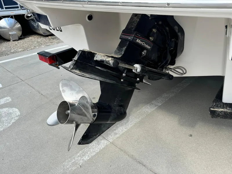 Slide: The Image of 2006 Regal 2200 Bowrider boat with MerCruiser outdrive and propeller, parked on concrete surface. - 9
