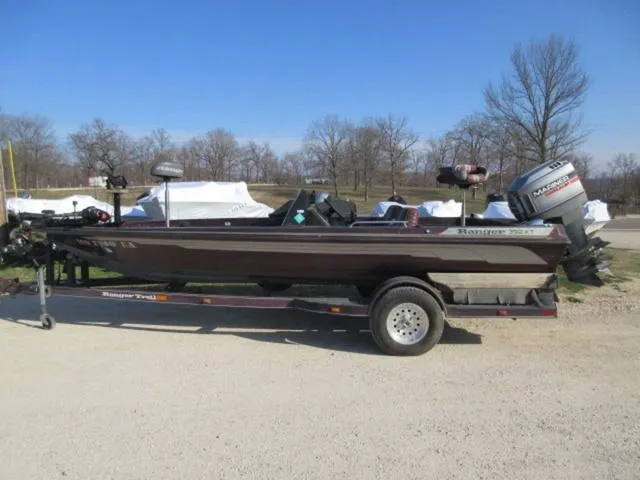 Slide: The Image of 1995 Ranger 392XT boat with Mariner 200 HP outboard on trailer, parked outdoors. - 1