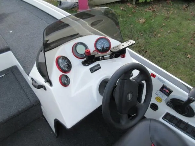 Slide: The Image of 2004 Champion 187 bass boat dashboard with steering wheel and gauges, featuring a Mercury 175Hp outboard. - 17