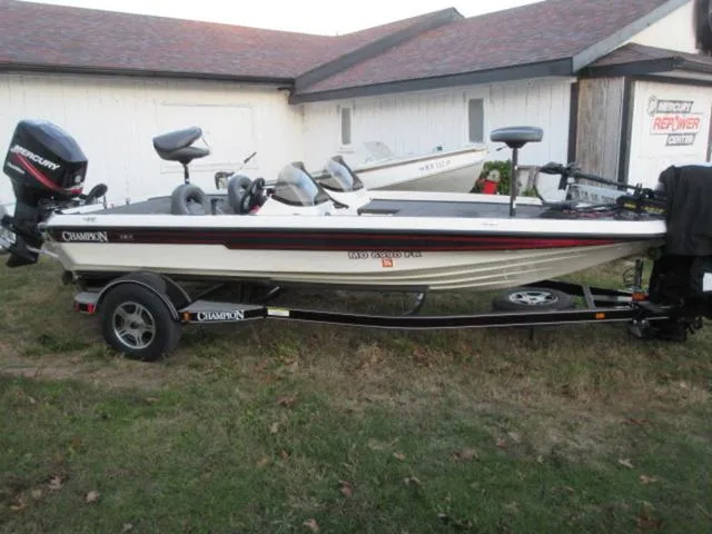 Slide: The Image of 2004 Champion 187 bass boat with Mercury 175Hp outboard, parked on grass. - 3
