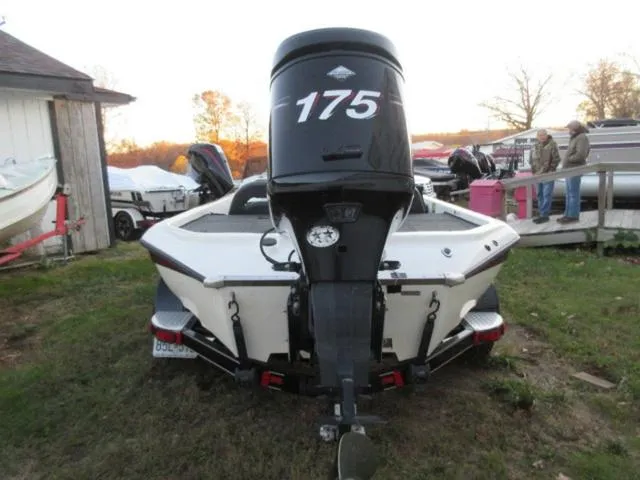 Slide: The Image of 2004 Champion 187 bass boat with Mercury 175Hp outboard, rear view, parked outdoors. - 4