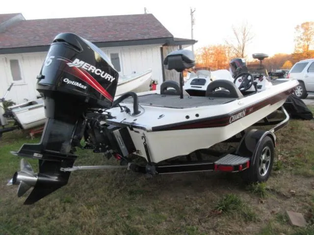 Slide: The Image of 2004 Champion 187 bass boat with Mercury 175Hp outboard, parked outdoors. - 8