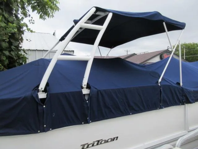 Slide: The Image of 2009 JC 26' Tritoon boat with blue cover and canopy, featuring 300Hp Evinrude Outboard. - 10