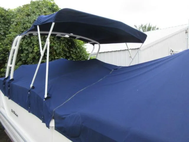 Slide: The Image of 2009 JC 26' Tritoon with blue cover and canopy, featuring 300Hp Evinrude Outboard. - 12