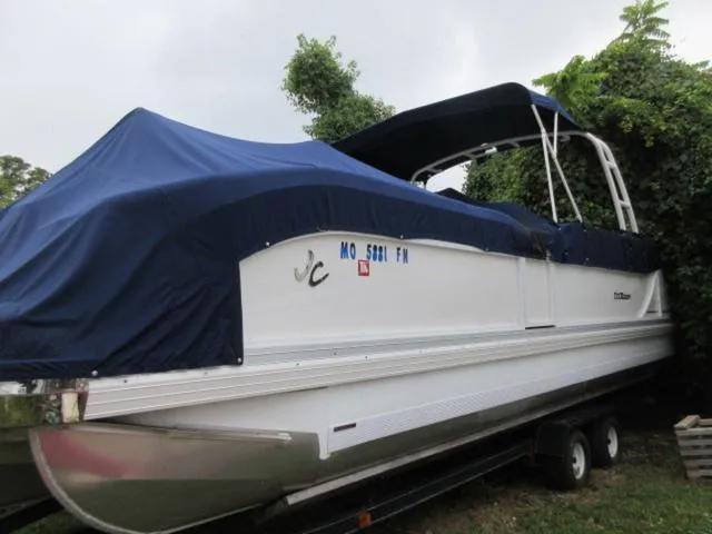 Slide: The Image of 2009 JC 26' Tritoon boat with 300Hp Evinrude outboard, covered and on trailer. - 13