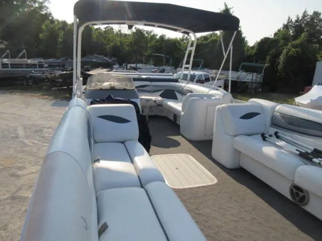 Slide: The Image of 2009 JC 26' Tritoon boat with 300Hp Evinrude outboard, featuring spacious seating and canopy. - 19