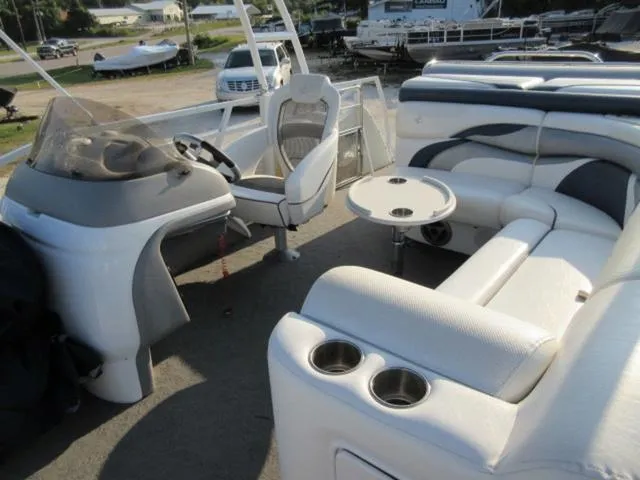 Slide: The Image of 2009 JC 26' Tritoon boat interior with seating, table, and steering console. - 20