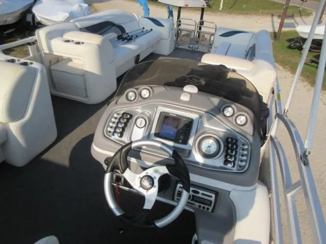 Slide: The Image of 2009 JC 26' Tritoon boat interior with steering console and seating, featuring 300Hp Evinrude Outboard. - 21