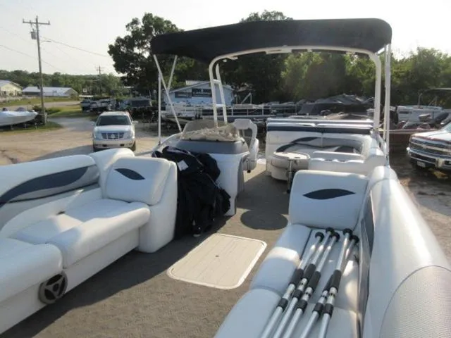 Slide: The Image of 2009 JC 26' Tritoon boat with 300Hp Evinrude outboard, featuring spacious seating and canopy. - 6