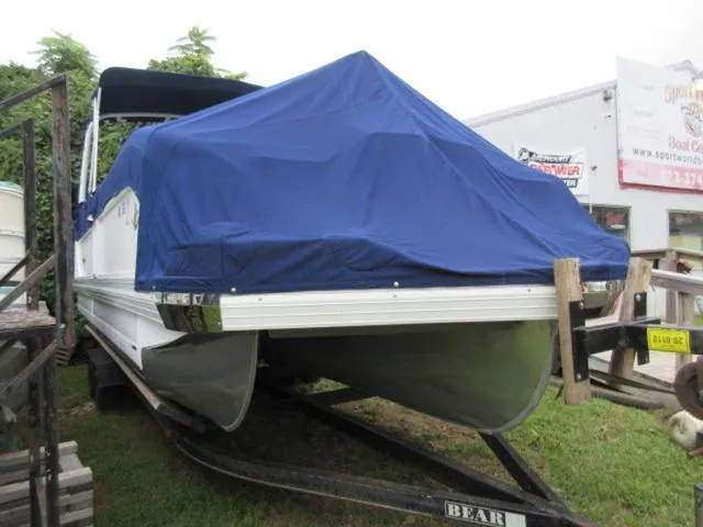 Slide: The Image of 2009 JC 26' Tritoon with blue cover on trailer, featuring 300Hp Evinrude Outboard. - 8