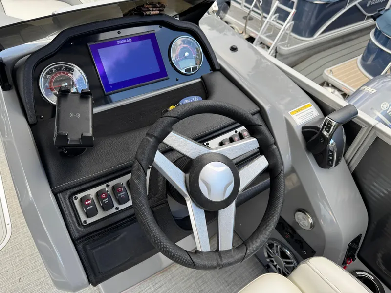Slide: The Image of 2023 Godfrey Monaco 255 SD boat dashboard with steering wheel and control panel. - 14