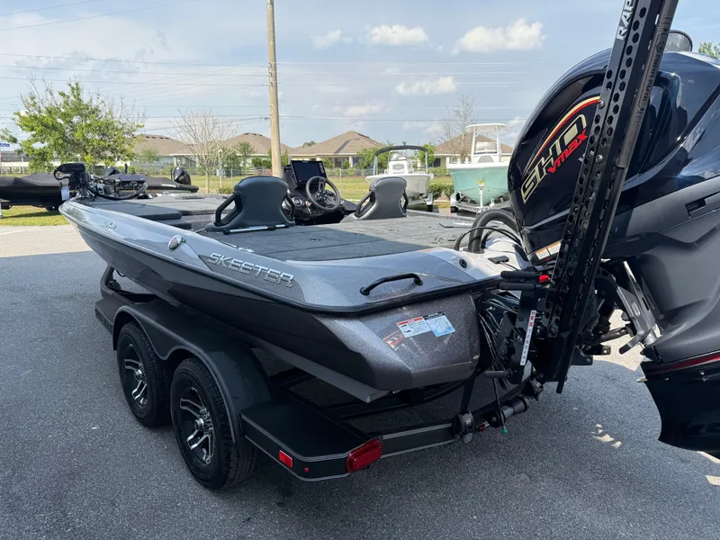 Slide: The Image of 2025 Skeeter ZXR20 boat on trailer, parked outdoors, featuring sleek design and powerful engine. - 11