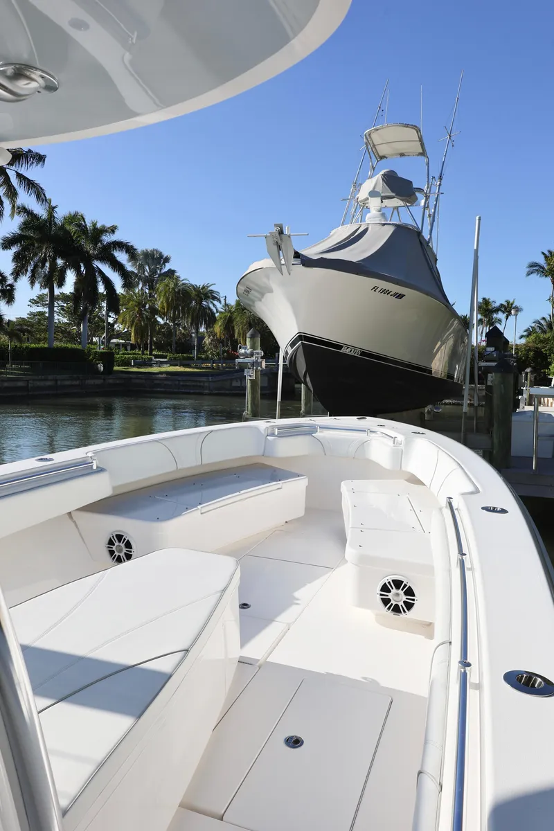 Slide: The Image of 2022 Contender 39 ST boat docked near palm trees under clear blue sky. - 11