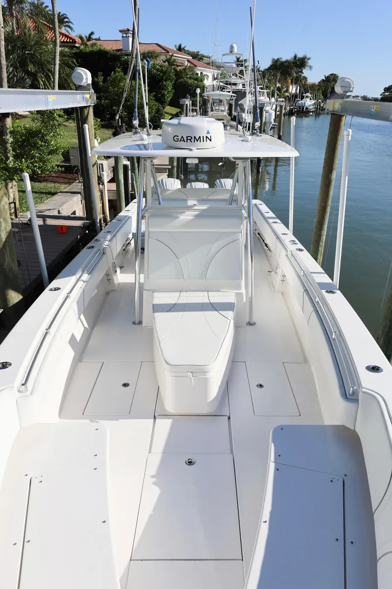 Slide: The Image of 2022 Contender 39 ST boat docked, featuring spacious deck and Garmin equipment. - 12