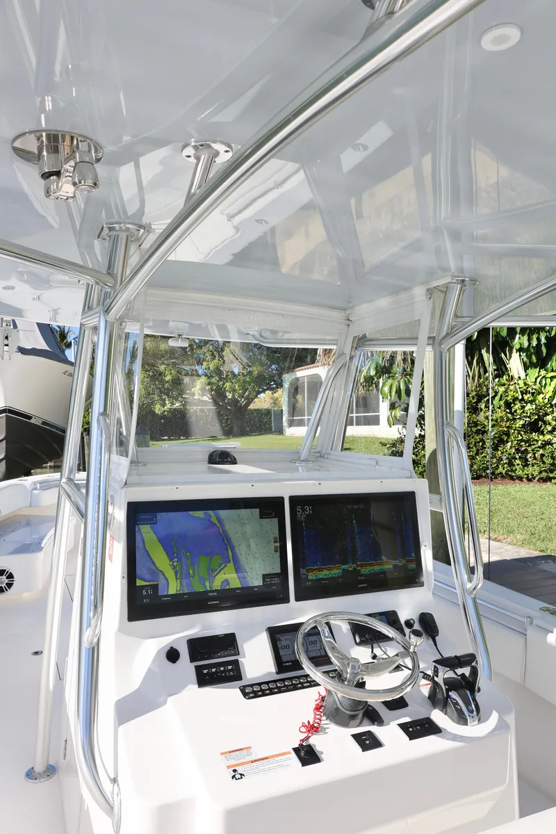 Slide: The Image of 2022 Contender 39 ST boat cockpit with dual navigation screens and steering wheel. - 14