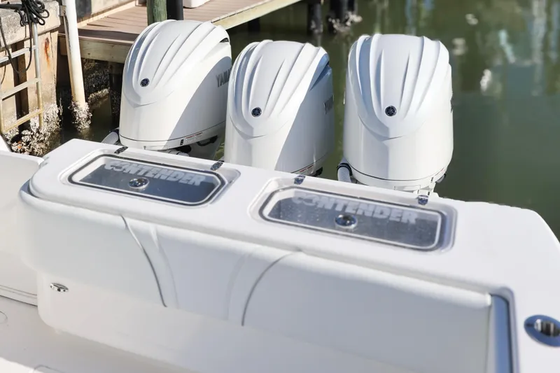 Slide: The Image of 2022 Contender 39 ST boat with triple outboard engines docked by the water. - 16
