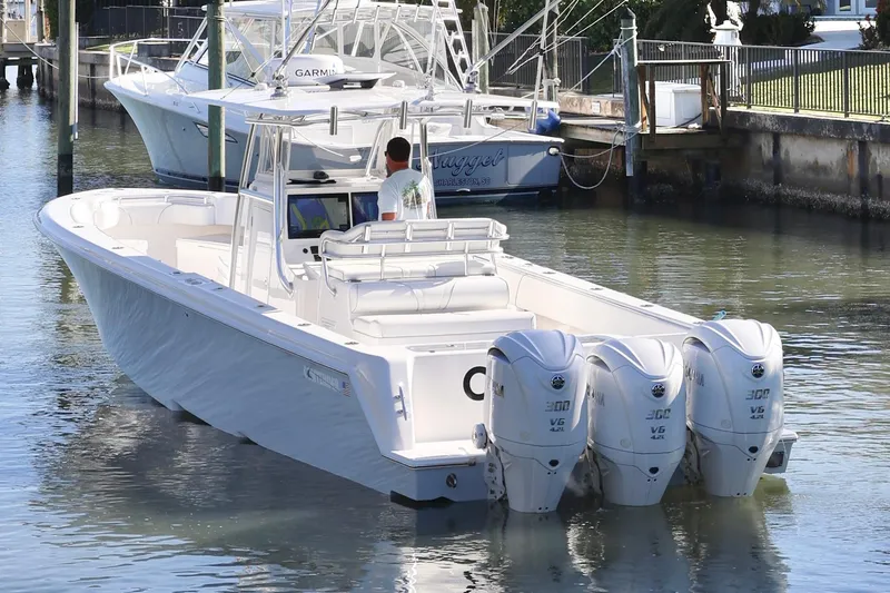 Slide: The Image of 2022 Contender 39 ST boat with triple engines docked in a marina. - 7