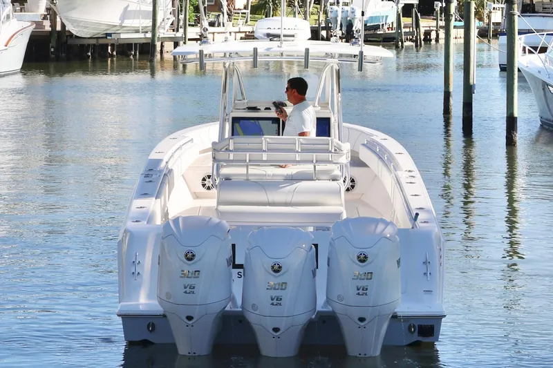 Slide: The Image of 2022 Contender 39 ST boat with triple engines, docked in a marina. - 9