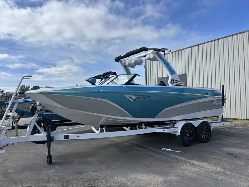Slide: The Image of 2025 Tigé Z3 boat on trailer, blue and white design, parked outdoors. - 0