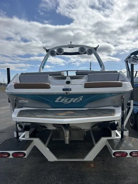 Slide: The Image of 2025 Tigé Z3 boat rear view with speakers and seating, under a cloudy sky. - 3
