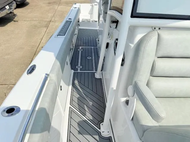 Slide: The Image of 2019 Sportsman Open 282TE Center Console boat interior with cushioned seating and non-slip flooring. - 7