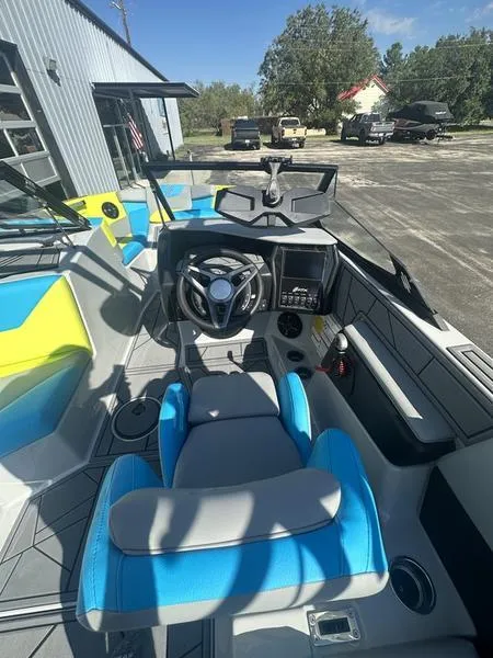 Slide: The Image of 2024 ATX Surf Boats 22 Type-S interior with blue and gray seating, steering wheel, and dashboard. - 2