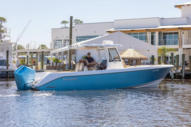 Slide: The Image of 2024 Everglades 315CC boat on water near modern waterfront buildings. - 10
