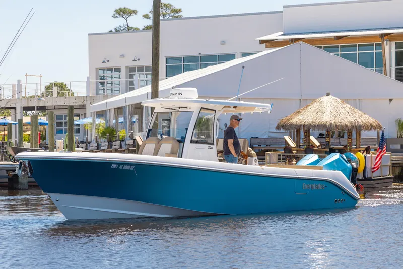 Slide: The Image of 2024 Everglades 315CC boat docked near waterfront restaurant. - 11
