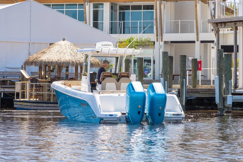 Slide: The Image of 2024 Everglades 315CC boat with dual engines docked near waterfront buildings. - 12