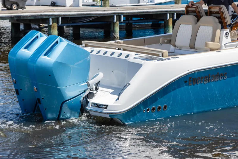 Slide: The Image of 2024 Everglades 315CC boat with dual outboard engines on water. - 13