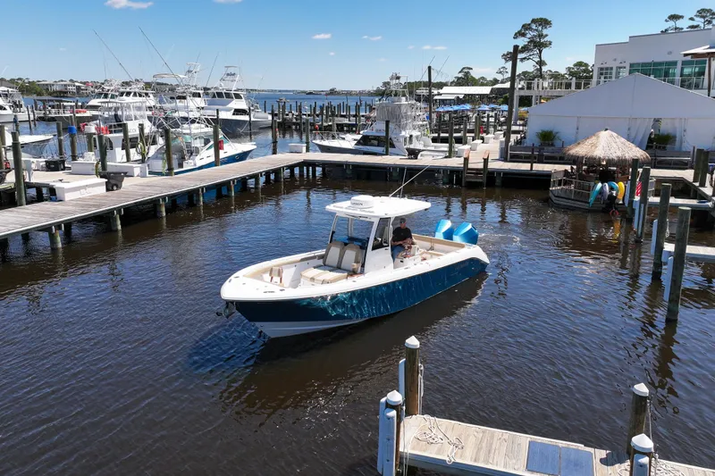 Slide: The Image of 2024 Everglades 315CC boat docked in a marina under clear blue skies. - 17