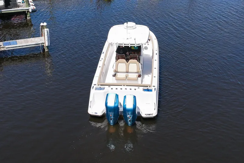 Slide: The Image of 2024 Everglades 315CC boat with dual engines on calm water. - 22
