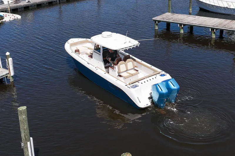 Slide: The Image of 2024 Everglades 315CC boat cruising in a marina, featuring a sleek design and powerful engine. - 23