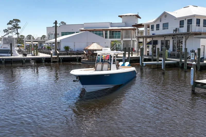 Slide: The Image of 2024 Everglades 315CC boat docked near waterfront buildings. - 24