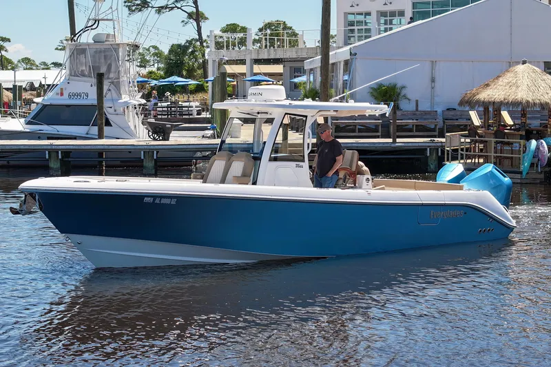 Slide: The Image of 2024 Everglades 315CC boat docked in marina, featuring sleek blue design and modern amenities. - 28